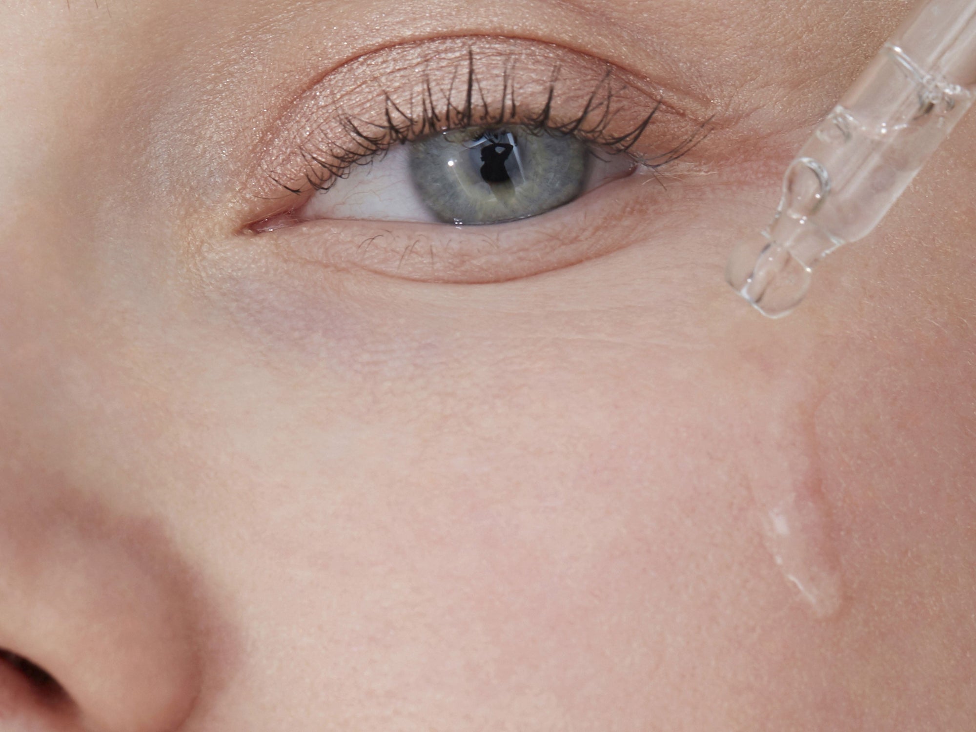 woman applying serum on her face